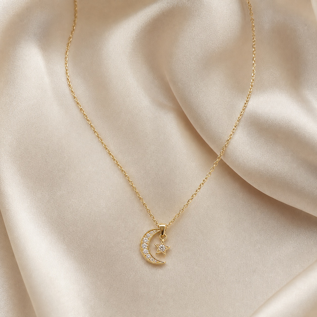 Celestial gold pendant necklace arranged on cream silk