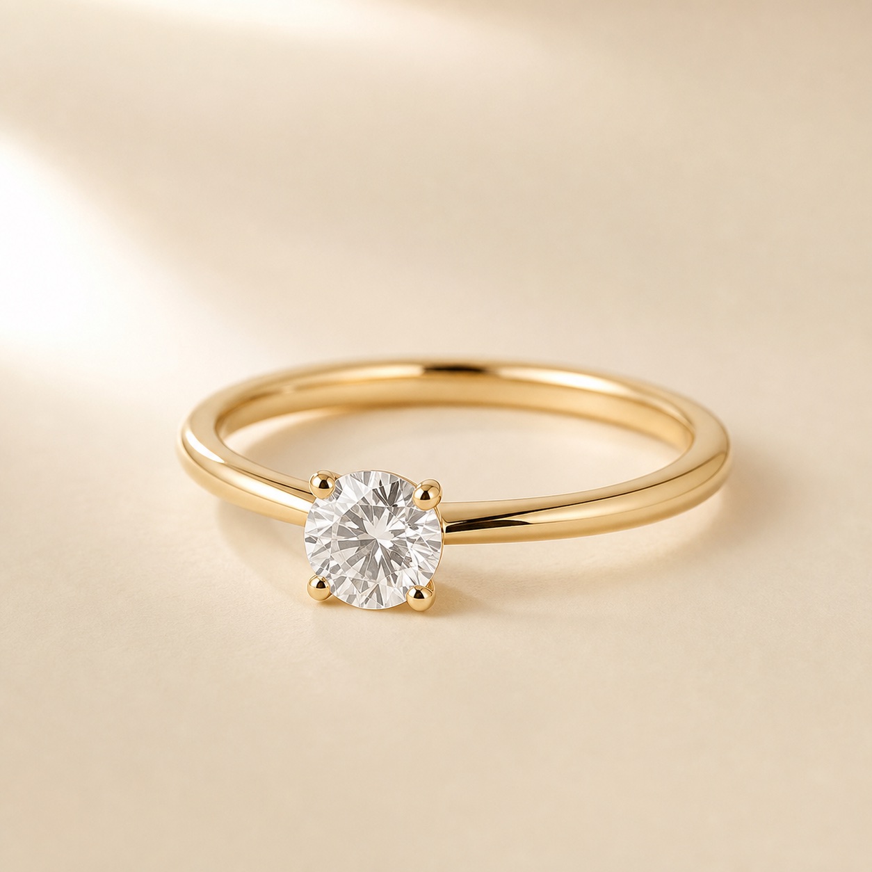 Diamond ring in warm yellow gold on an ivory surface